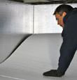 A contractor installing TerraBlock™ floor insulation in a Mountlake Terrace crawl space