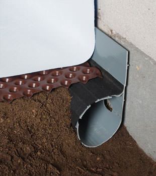 Closeup of a crawl space drainage system installed in Bow